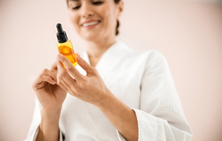 Woman examining vitamin C serum for skin benefits